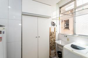 baño blanco con lavabo y ventana en Temporada Santa Tereza - Conforto e Tranquilidade en Río de Janeiro