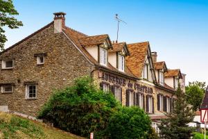 een oud stenen gebouw met een bord erop bij L’Auberge du Château in Dampierre