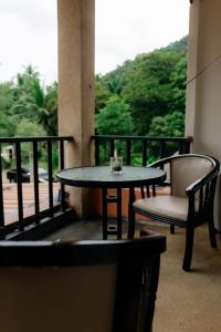 une table et deux chaises assises sur un balcon dans l'établissement Aonang Knockout Hostel, à Ao Nang Beach