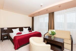 Habitación de hotel con cama y sofá en Hotel Kudowa Manufaktura Relaksu, en Kudowa-Zdrój