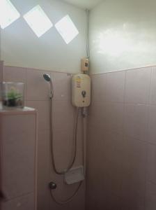 a shower in a bathroom with a phone on the wall at Aonang Knockout Hostel in Ao Nang Beach