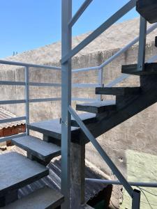 un conjunto de escaleras que conducen a un edificio en Kitnets da Tia Zeni, en Arraial do Cabo