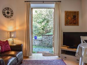 uma sala de estar com televisão e uma grande janela em Allerton House Stable em Jedburgh