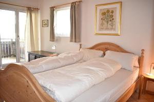 een bed met witte lakens in een kamer bij Tgamutsch (461 Tä) in Lenzerheide