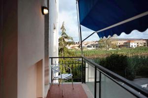 a chair on a balcony with a view of a field at Le Vele in Albissola Marina