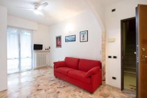 um sofá vermelho sentado numa sala de estar em Le Vele em Albissola Marina