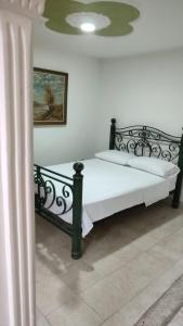 - une chambre avec un lit doté d'un cadre en métal noir dans l'établissement Apartamento en Ibague, à Ibagué