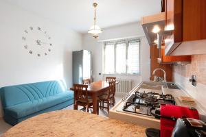 a kitchen with a blue couch and a stove top oven at Le Vele in Albissola Marina
