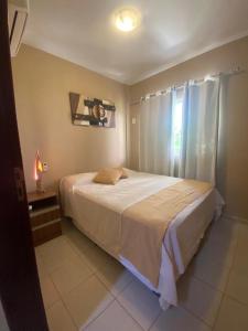 a bedroom with a large bed and a window at Paraiso de Maracajau 4 in Maracajaú