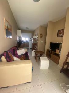 a living room with a couch and a tv at Paraiso de Maracajau 4 in Maracajaú