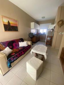 ein Wohnzimmer mit einem Sofa und einem Tisch in der Unterkunft Paraiso de Maracajau 4 in Maracajaú