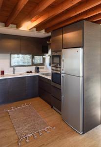 a kitchen with a stainless steel refrigerator and wooden cabinets at VILLA MATELIA in Neos Marmaras