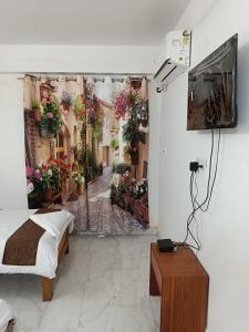a bedroom with a painting of an alley with flowers at HOTEL ATITHI GRAND in Guwahati