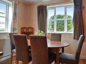 a dining room with a wooden table and chairs at Cobblers Cottage in Sawston
