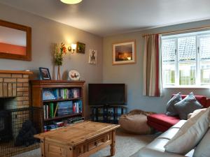 a living room with a couch and a coffee table at Cobblers Cottage in Sawston