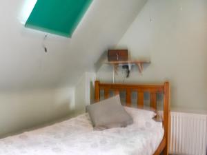 a small bedroom with a wooden bed with a pillow at Cobblers Cottage in Sawston