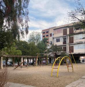 un parque de juegos vacío en un parque junto a un edificio en Departamento Alsina al mil en Salta