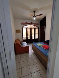 une chambre avec un lit, une chaise et une fenêtre dans l'établissement Seu Apto na Praia da Costa 9 Simples e Barato Mobiliado Ar Cond Fogão TV Geladeira Local Excelente no Centro, à Vila Velha