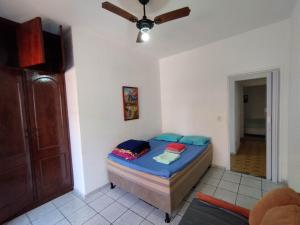 une chambre avec un lit et un ventilateur de plafond dans l'établissement Seu Apto na Praia da Costa 9 Simples e Barato Mobiliado Ar Cond Fogão TV Geladeira Local Excelente no Centro, à Vila Velha