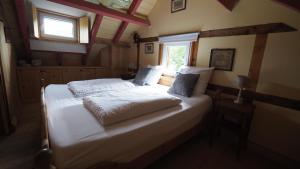 1 dormitorio con 1 cama con sábanas blancas y ventana en Jagthaus am Rappelstein, en Schmallenberg