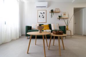 sala de estar con sofá verde y 2 mesas en Venegas Urban Suites By Bevacacional, en Las Palmas de Gran Canaria