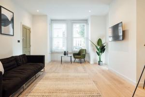 Luxurious & Modern London Apartment in Honor Oak في لندن: غرفة معيشة مع أريكة وطاولة