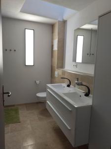 uma casa de banho com um lavatório branco e um WC. em Haus Harry em Eisenach
