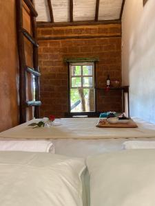 um quarto com 2 camas e uma janela em Abrigo Cipó em Serra do Cipó
