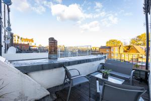 a patio with chairs and tables on a balcony at Stunning 2BR Apt wPatio in Dalston, 2 min to Tube in London