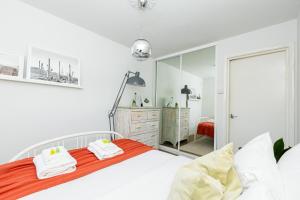 a bedroom with a bed and a large mirror at Stunning 2BR Apt wPatio in Dalston, 2 min to Tube in London