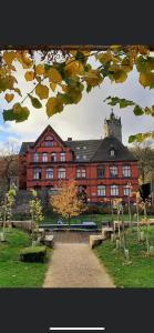 a large red brick building with a tree in front of it at back to school (rote Schule) in Andernach