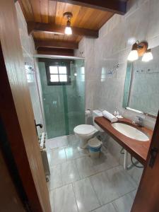 uma casa de banho com um WC, um lavatório e um chuveiro em Hotel Aconchego da Serra em Gramado