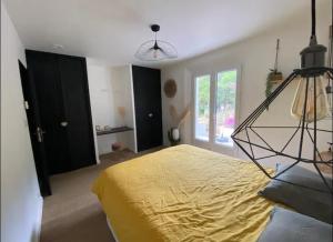 a bedroom with a large bed with a yellow bedspread at La louva in Les Brugassières