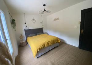 a bedroom with a bed with a yellow bedspread at La louva in Les Brugassières