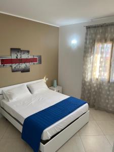 een slaapkamer met een groot bed met een blauwe deken bij Mare Blu Apartament in Balestrate