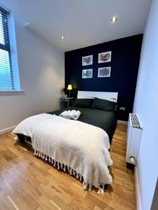 ein Schlafzimmer mit einem großen Bett und einer schwarzen Wand in der Unterkunft Beautiful 1 Bed Flat close to Clapham Trendy in London