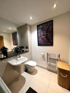 ein Bad mit einem WC, einem Waschbecken und einem Waschbecken in der Unterkunft Beautiful 1 Bed Flat close to Clapham Trendy in London