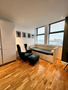 ein Wohnzimmer mit einem Sofa und einem Stuhl in der Unterkunft Beautiful 1 Bed Flat close to Clapham Trendy in London