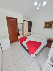 1 dormitorio con 1 cama grande con manta roja en Pousada Santa Barbara en Florianópolis