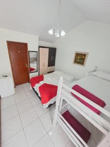 1 dormitorio con 2 camas y manta roja en Pousada Santa Barbara, en Florianópolis