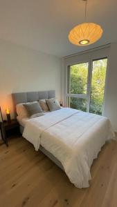 Tempat tidur dalam kamar di Les Terrasses de Lavaux 2 - Appartement de Luxe avec Vue Panoramique et Piscine"