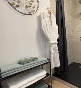 La salle de bains est pourvue d'un peignoir blanc accroché au mur. dans l'établissement Le Sainte Croix Hyper Centre Metz, à Metz