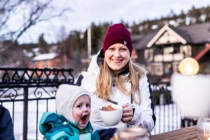 a woman and a child eating food at a table at Straand Hotel in Vradal