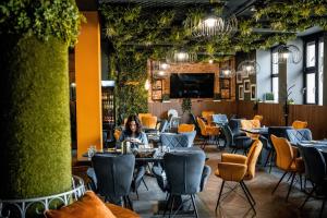 a woman sitting at a table in a restaurant at R73 Residences in Pécs