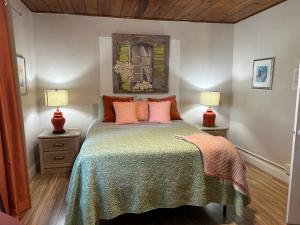 um quarto com uma cama com almofadas cor-de-rosa e 2 candeeiros em Palm Beach Mermaid em West Palm Beach