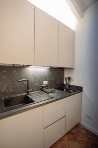 a kitchen with white cabinets and a sink at Il rustico DN ART holidays home - alloggio tipico in Blevio +27 photos