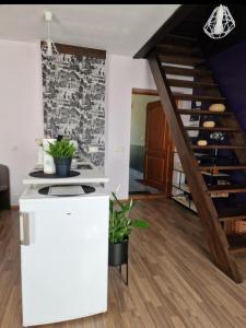 a kitchen with a staircase and a white refrigerator at CozyPlace in Kuldīga