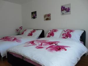 オロモウツにあるApartment Fialkaのベッドルームにピンクの花が飾られたベッド2台