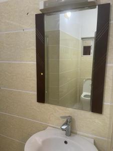 a bathroom with a sink and a mirror and a toilet at Studio meuble sacre cœur in Dakar