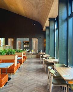 a restaurant with wooden tables and chairs and tables and windows at Bracken Hide Hotel in Portree